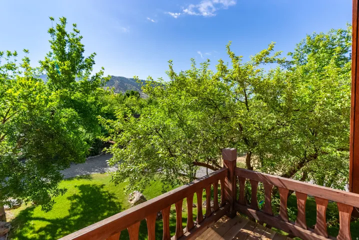 Balcony featuring wood-finish railing and flooring