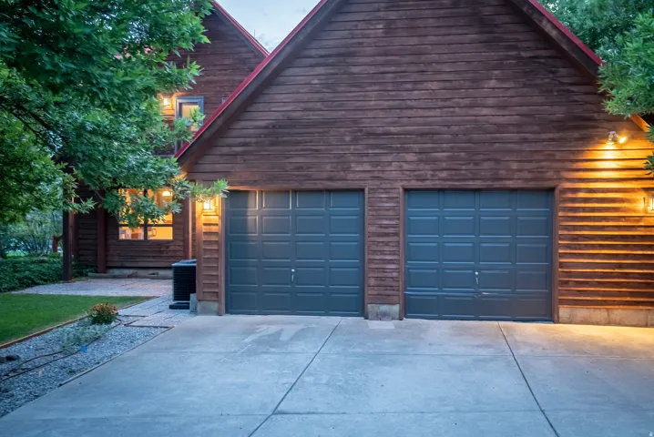 Two-car garage with dark paneled doors and a concrete driveway
