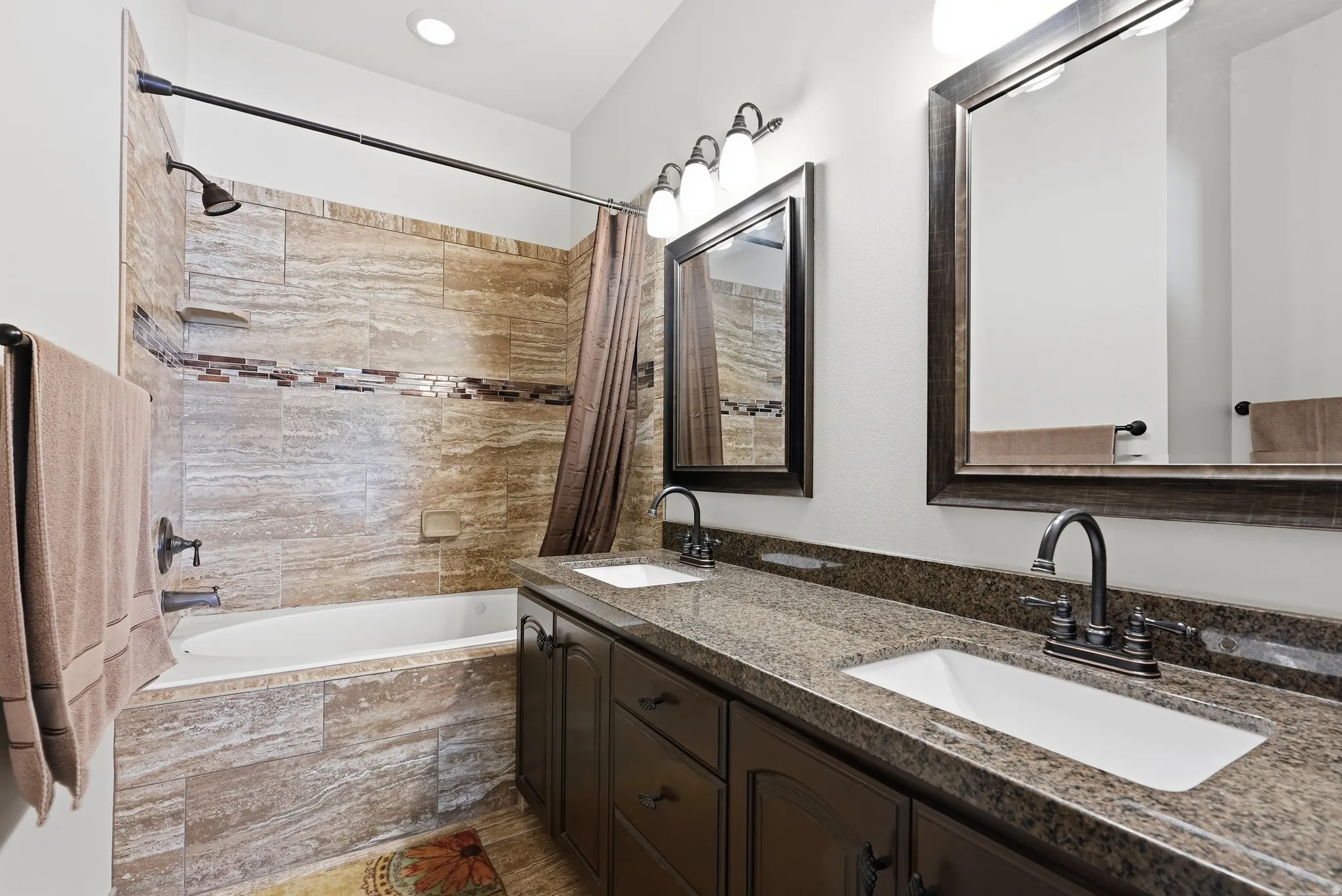 Dual vanity with granite countertops and dark wood-finish cabinetry