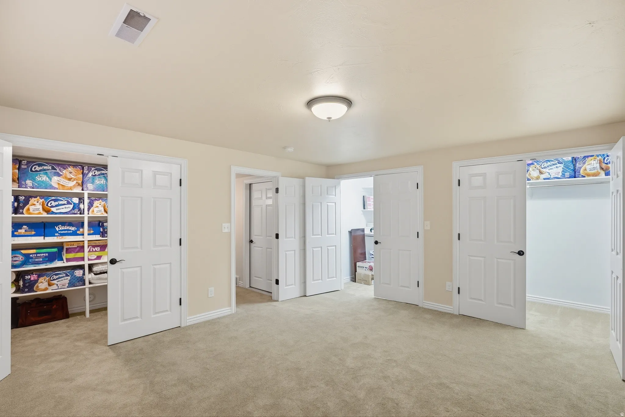 Neutral-toned room featuring light beige walls and carpeting
