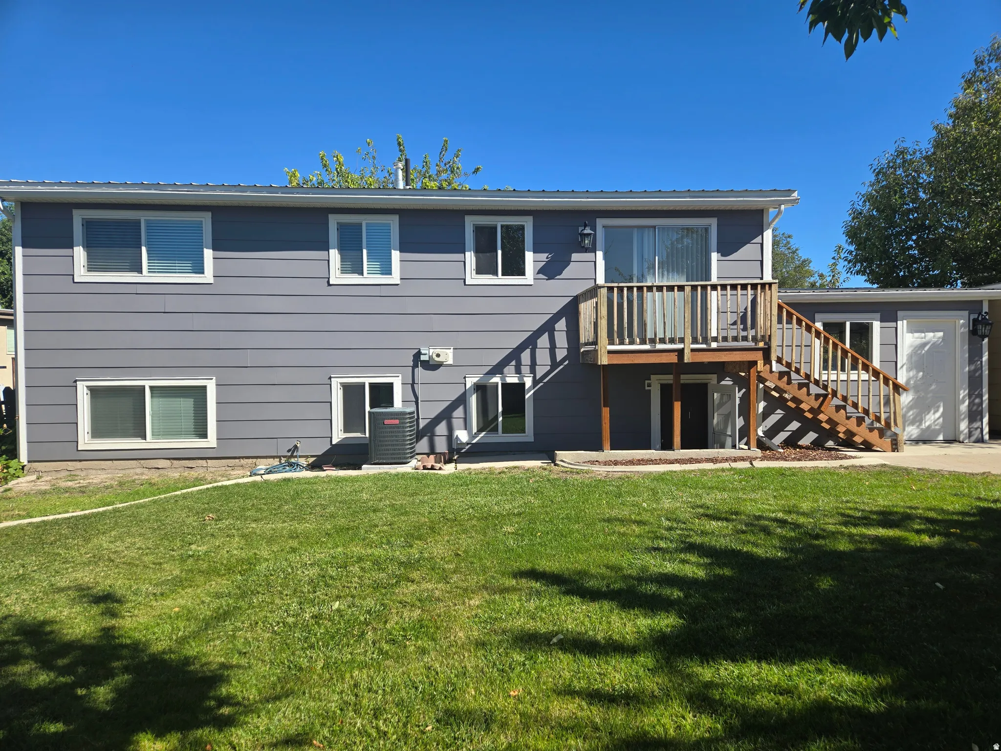 Rear exterior with gray horizontal siding and white trim