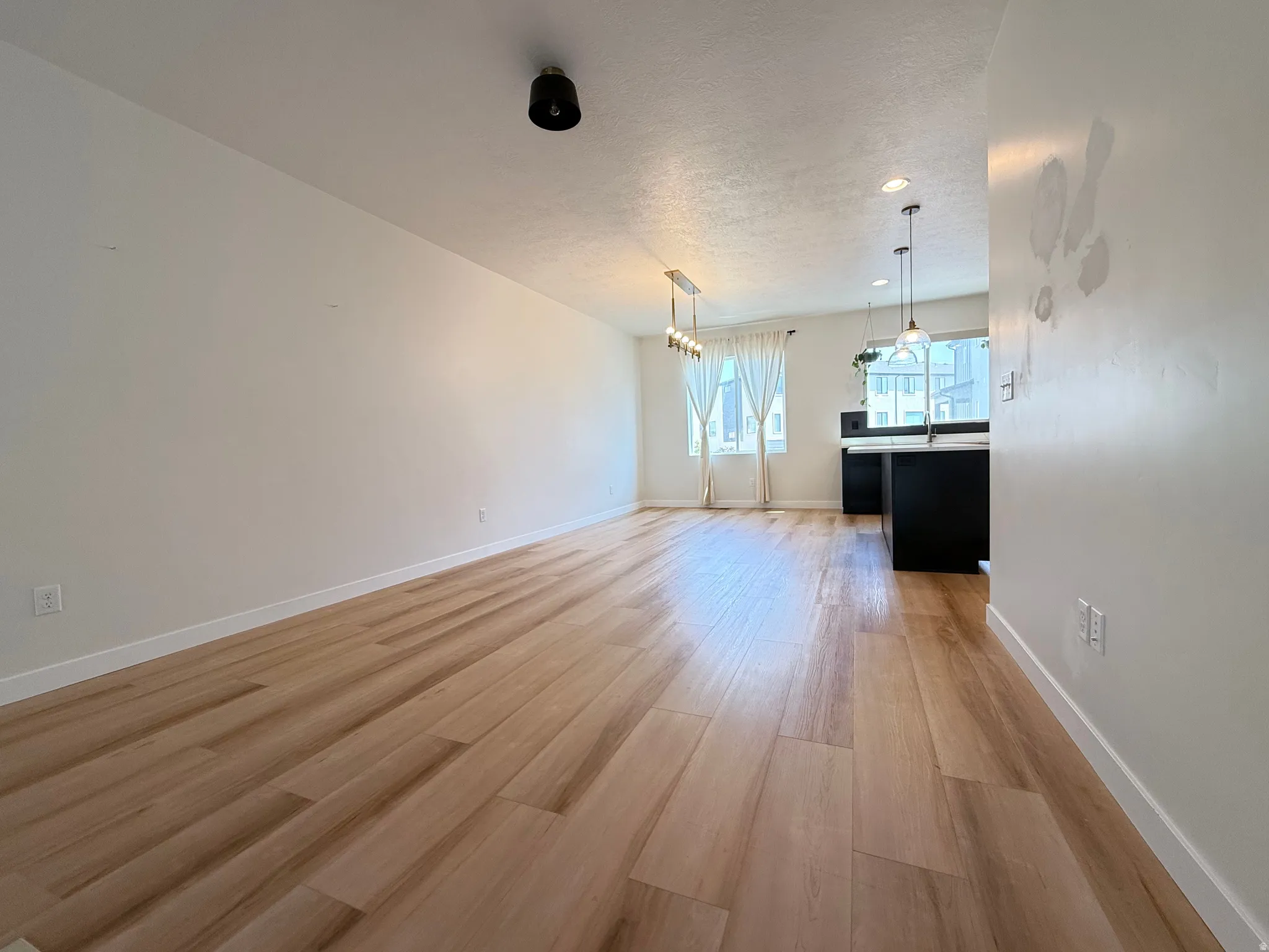 Wood-finish flooring throughout, bright white walls, and recessed lighting