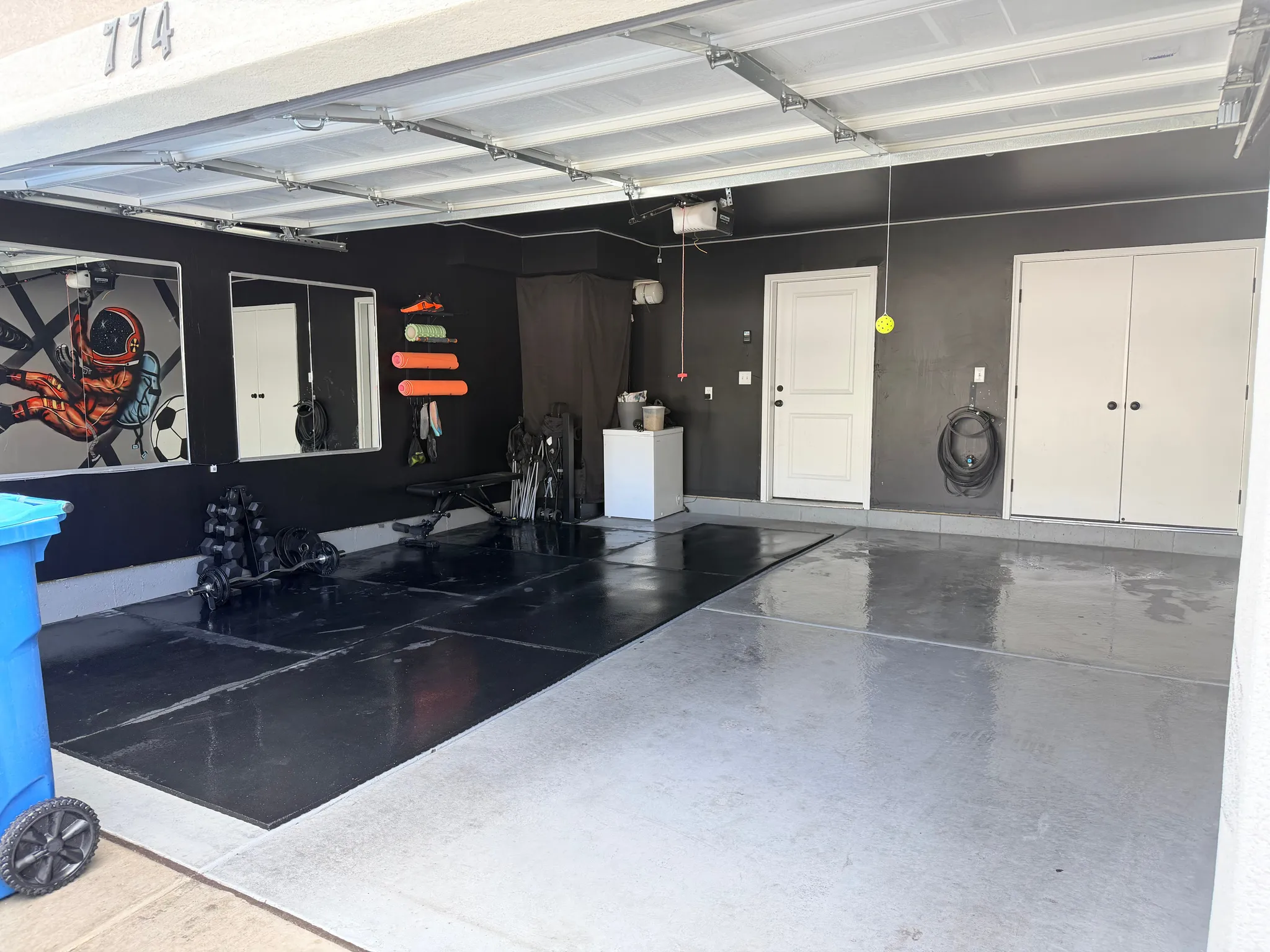 Garage featuring an epoxy coated floor, a built-in storage cabinet, and a white paneled entry door