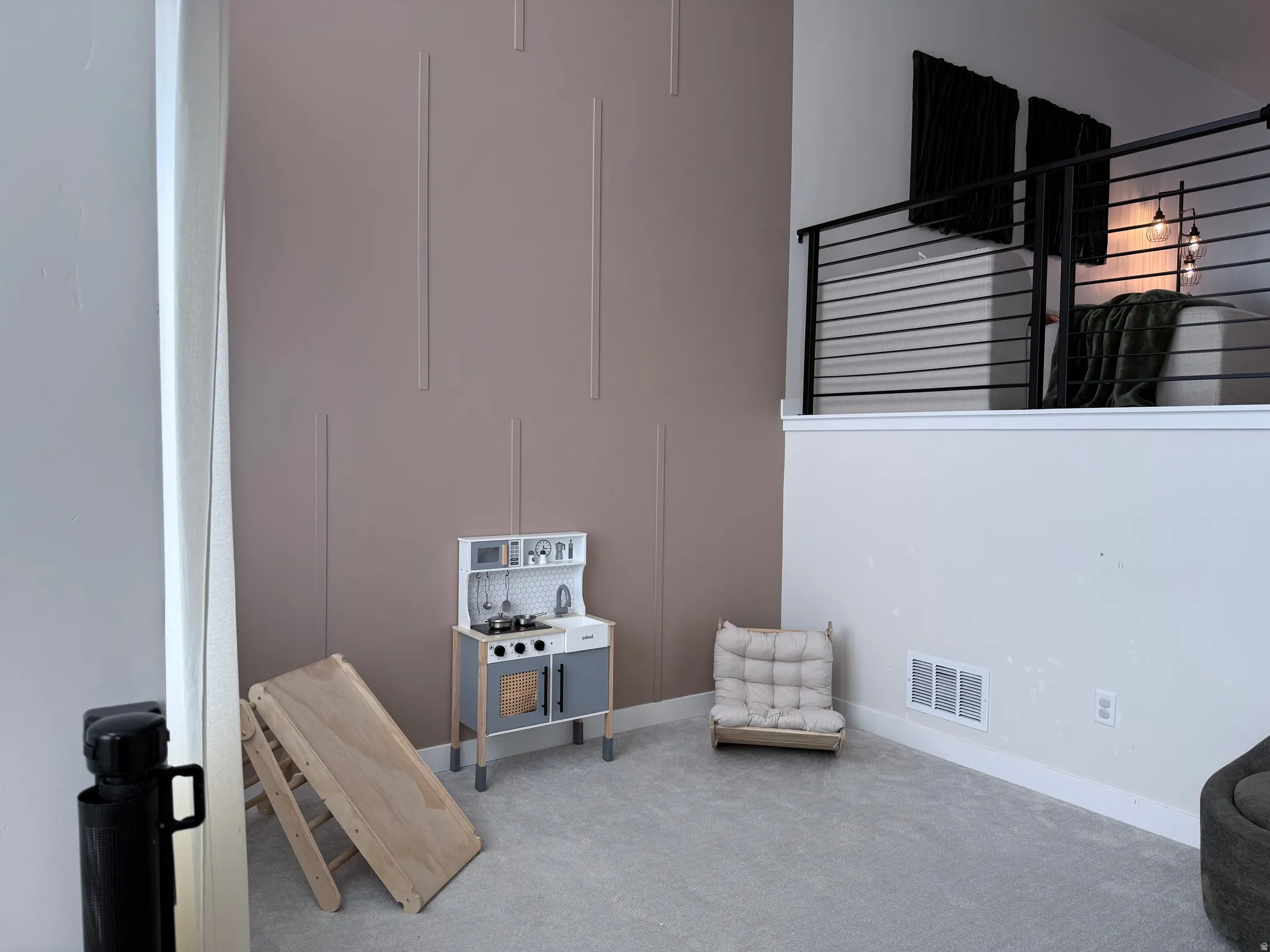 Loft area featuring a contemporary cable railing system and light gray carpeting
