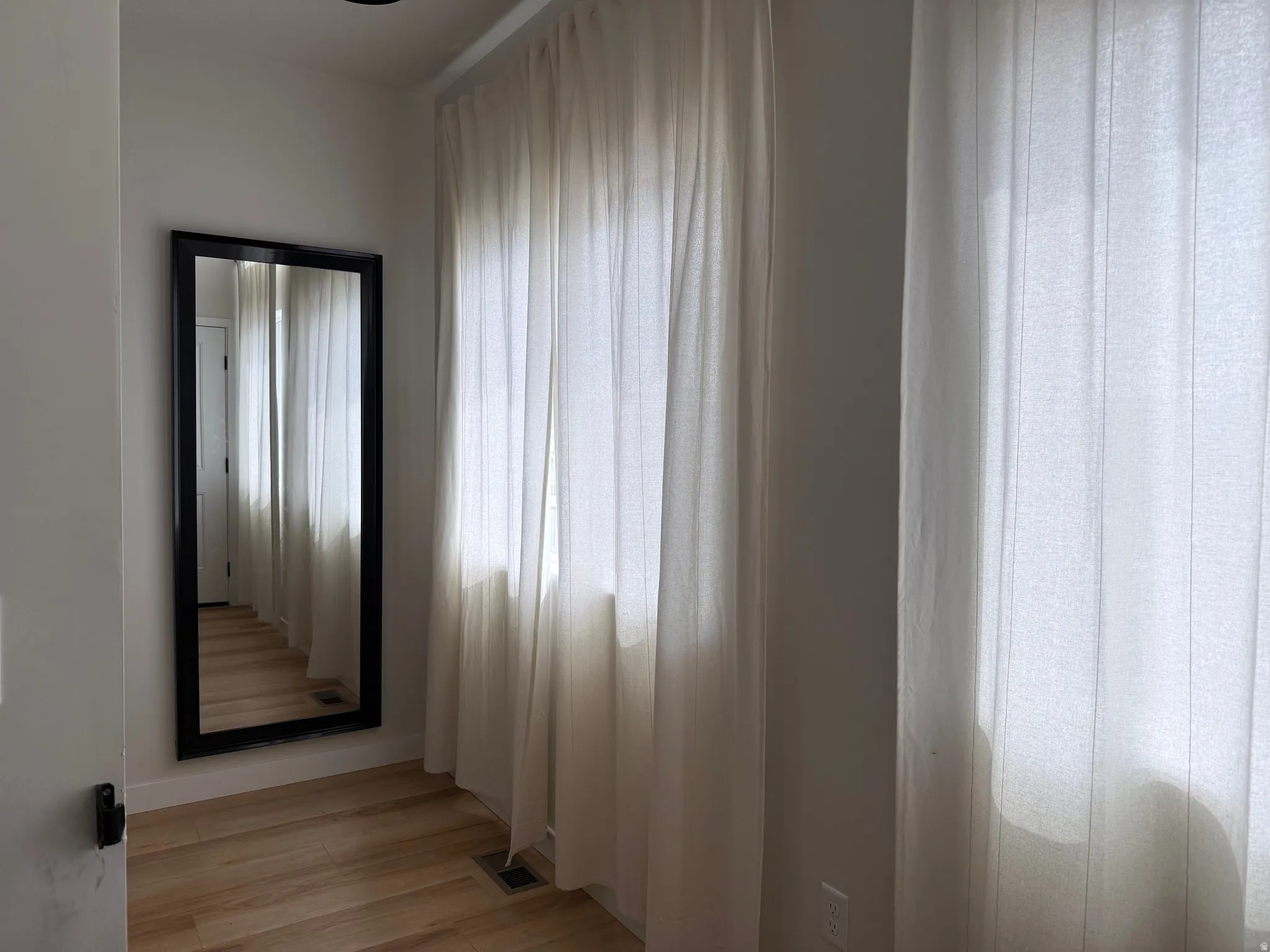 Bright interior space featuring light wood-finish flooring, white walls, and recessed ceiling lighting