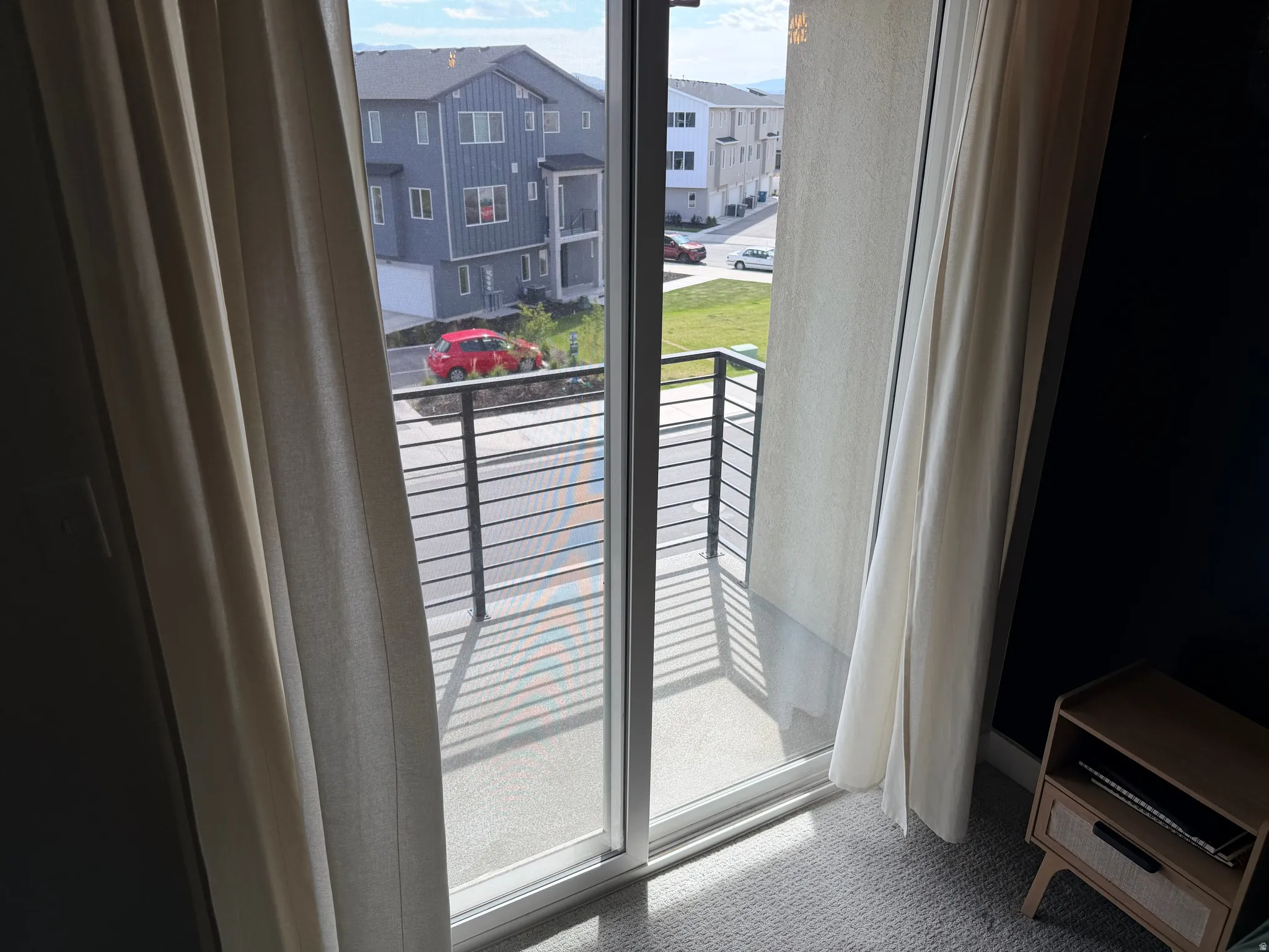 Sliding glass door opening to a private balcony with metal railings