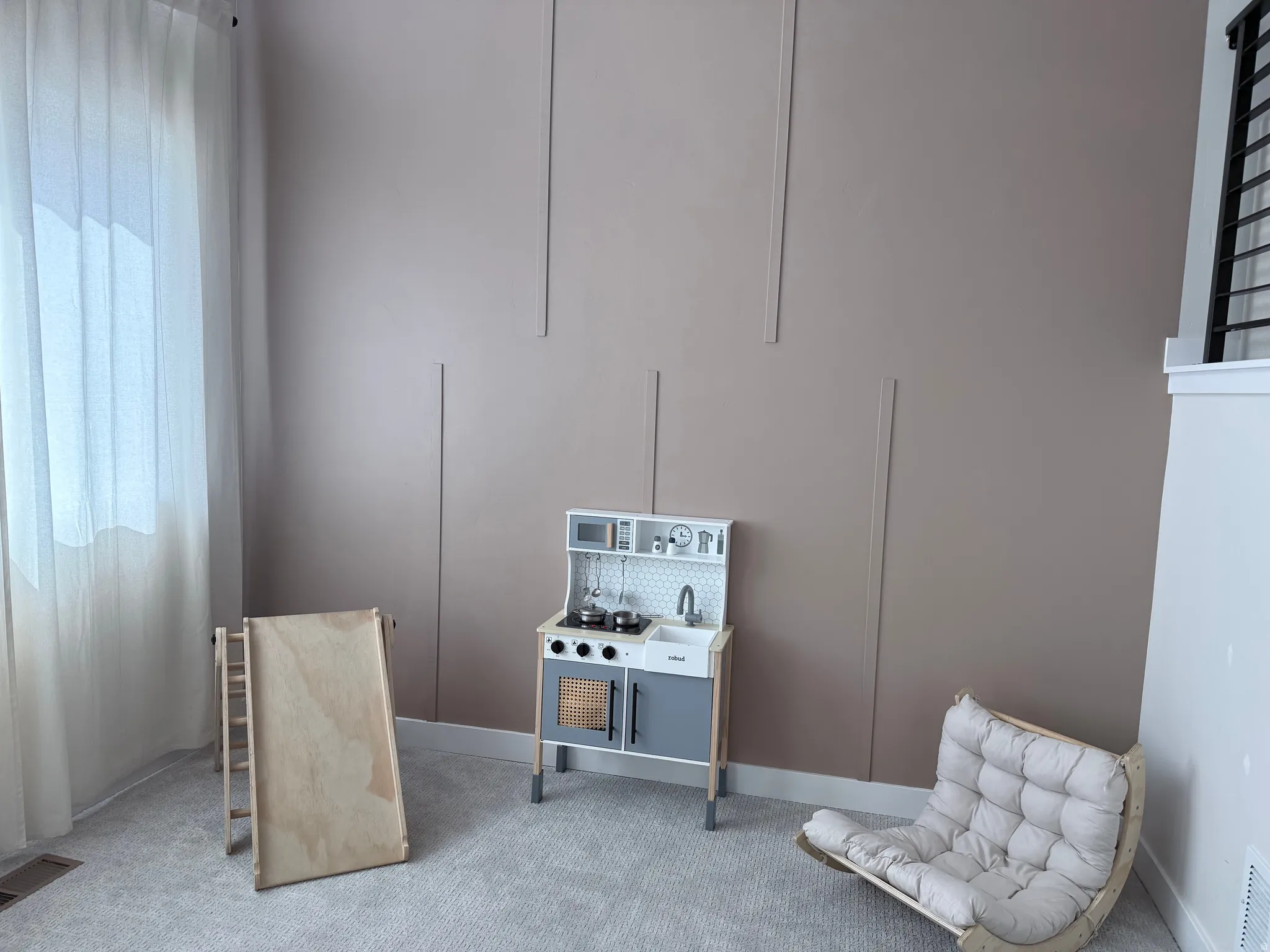 Wall paneling detail in a neutral tone with light-colored carpeting