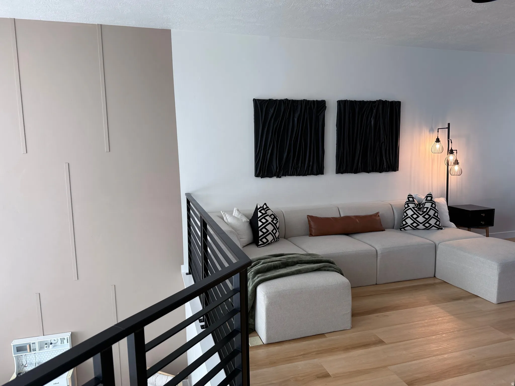 Interior space featuring a modern black metal horizontal bar railing overlooking a living area
