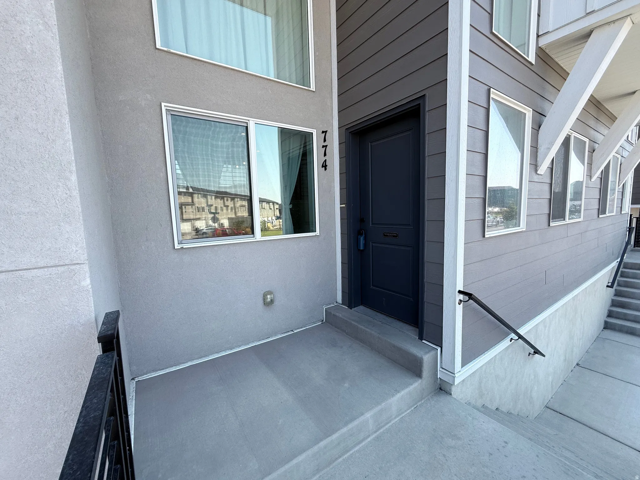 Modern exterior featuring horizontal siding, stucco, and a dark entry door