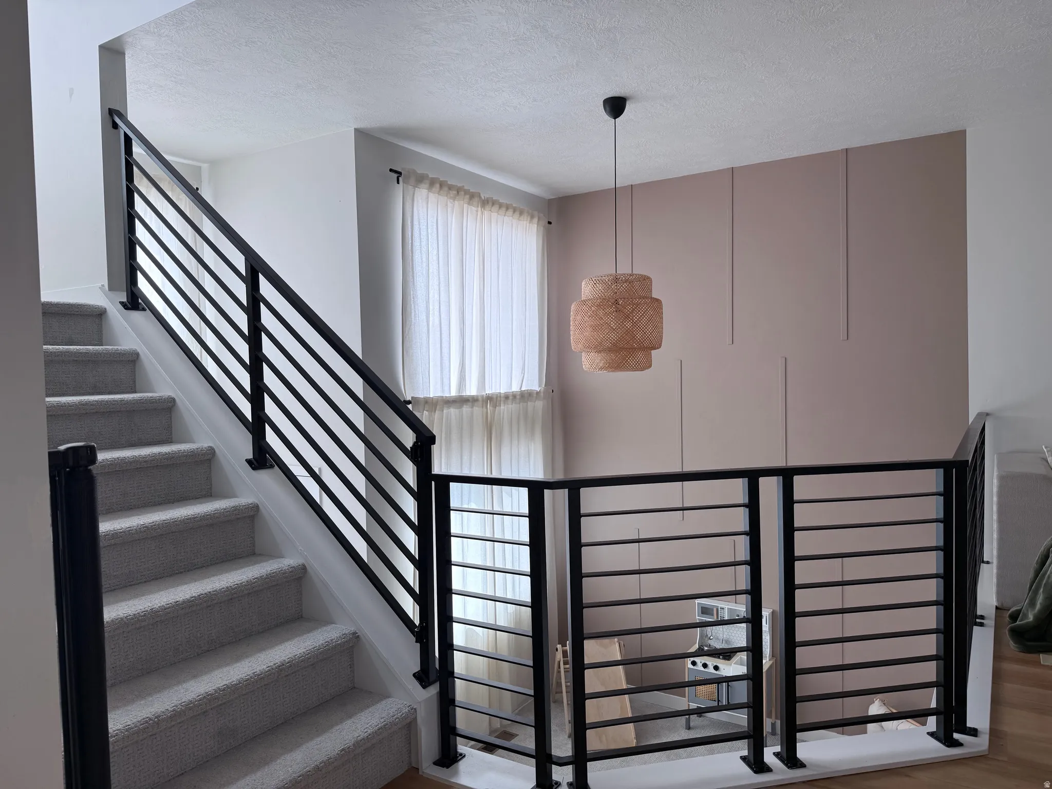 Contemporary horizontal black metal railing system on a carpeted staircase