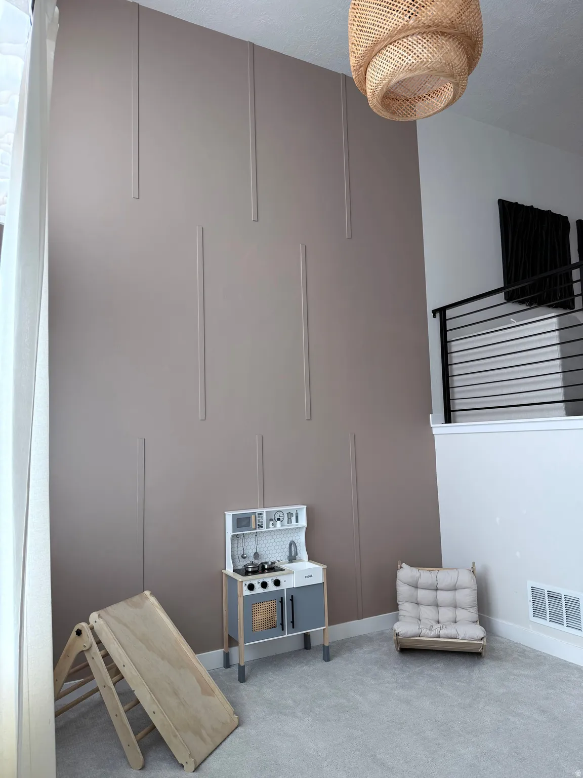 Two-story accent wall with vertical paneling, textured ceiling, and recessed lighting