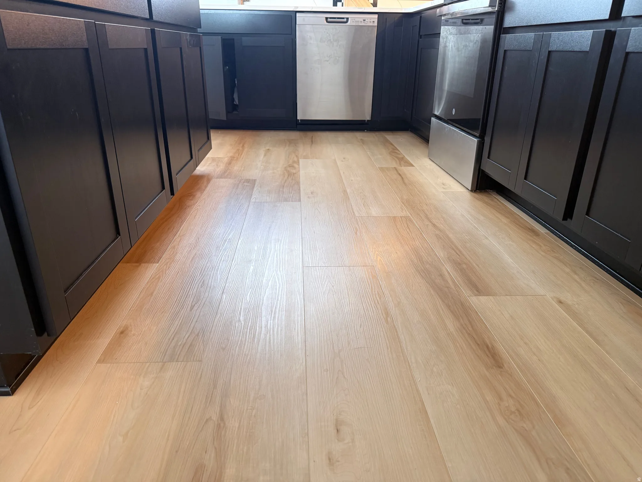 Light wood-finish flooring complemented by dark cabinetry