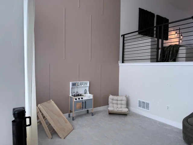 Loft area featuring a contemporary cable railing system and light gray carpeting