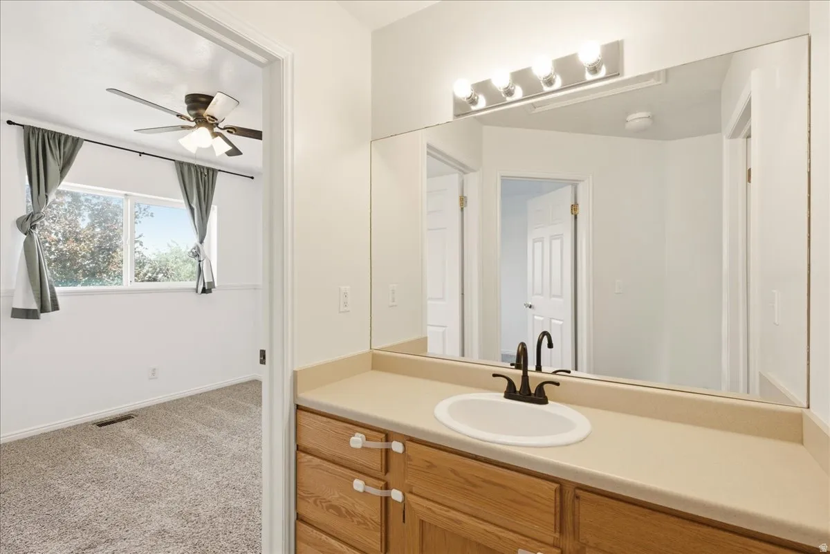 Bathroom vanity with an integrated sink, broad mirror, and a four-light fixture