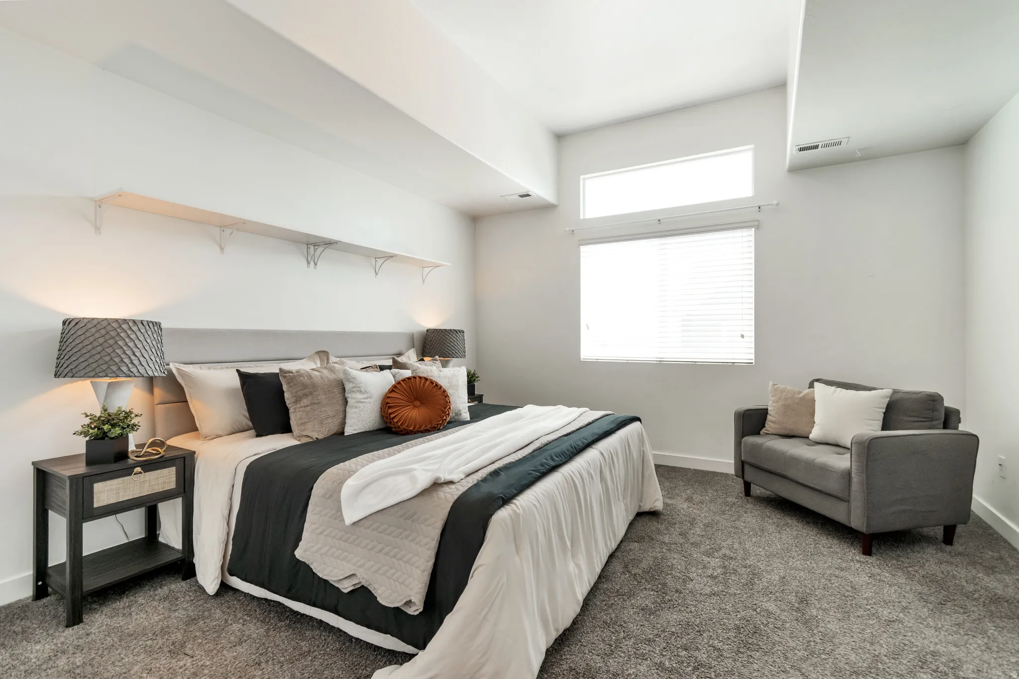 Spacious room featuring carpeting, high ceilings, large windows with blinds, built-in wall shelving, and a built-in recessed lighting channel