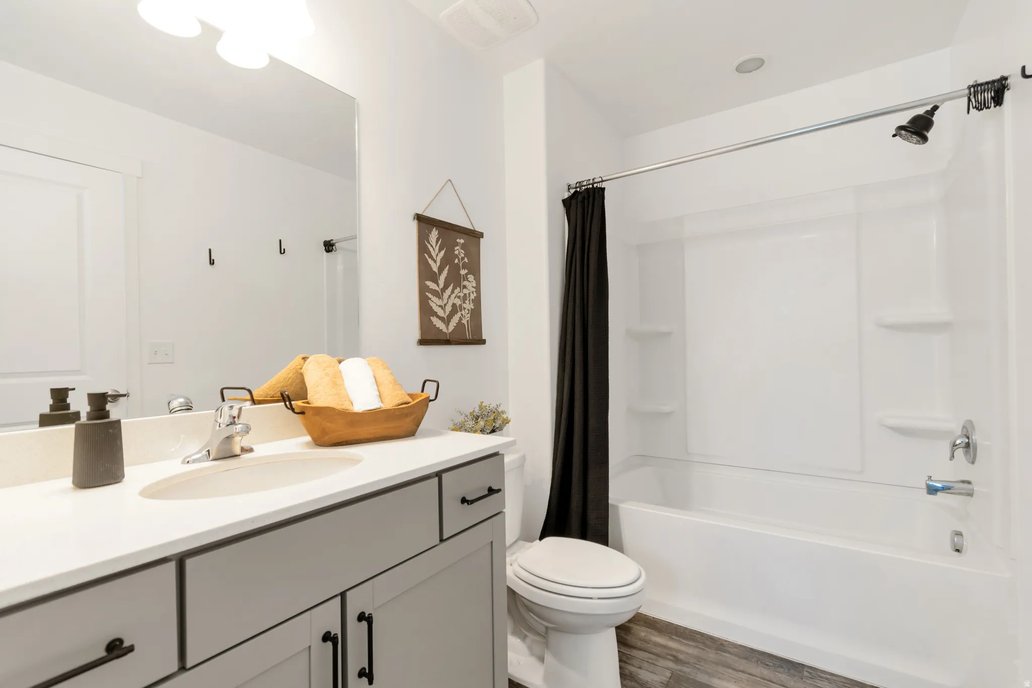 Bathroom featuring a single vanity with light gray cabinetry, a white countertop, and a basin sink