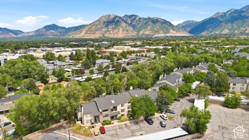 Residential community featuring multiple buildings with gabled roofs, surrounded by mature trees