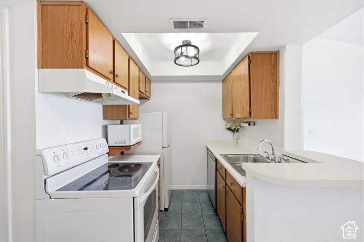 Galley kitchen featuring oak-finish cabinetry, white countertops, and a white electric range