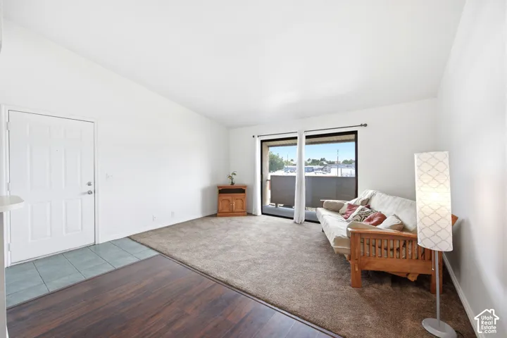 Living area with white walls and a vaulted ceiling