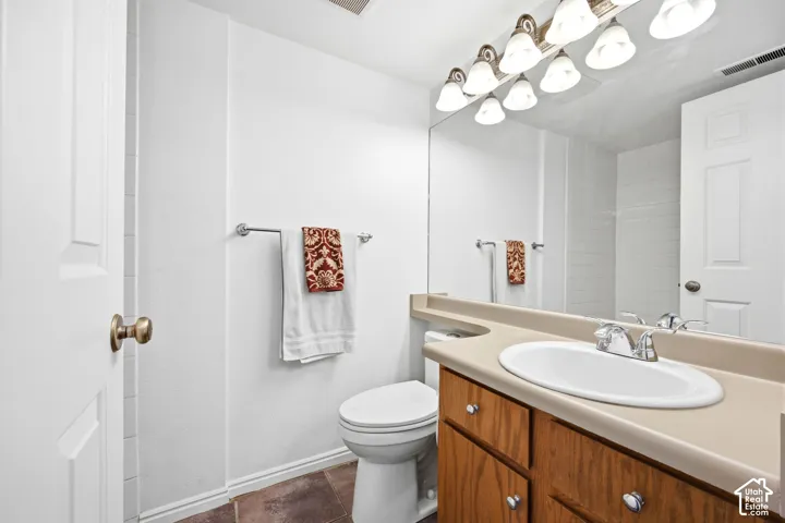 Bathroom vanity featuring a light-colored countertop with an integrated sink and chrome faucet