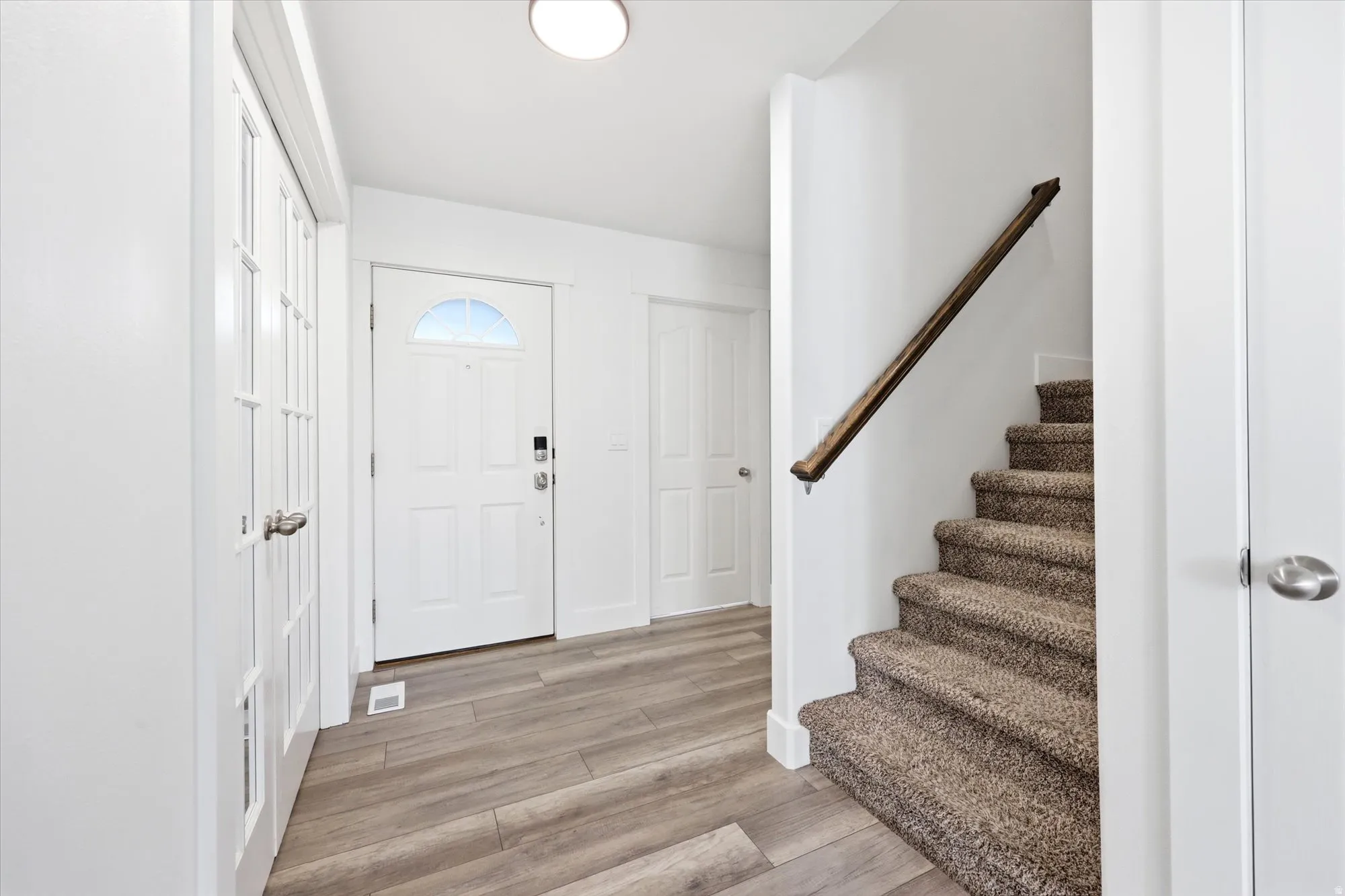 Entryway featuring wood-finish flooring, white walls, and a recessed ceiling light