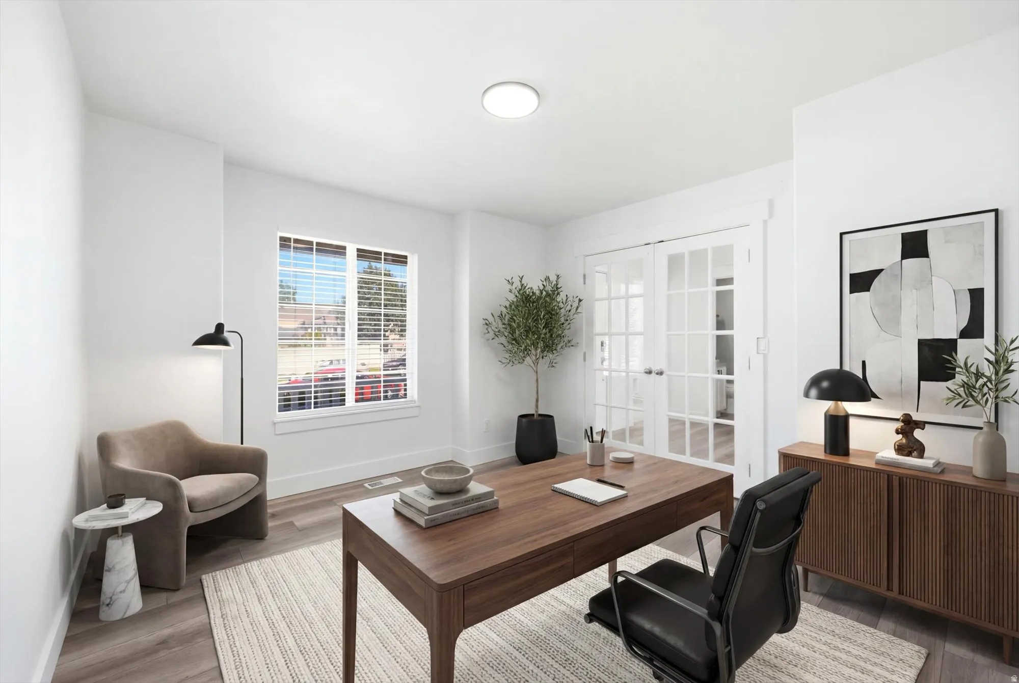Bright room featuring wood-finish flooring and a white color palette