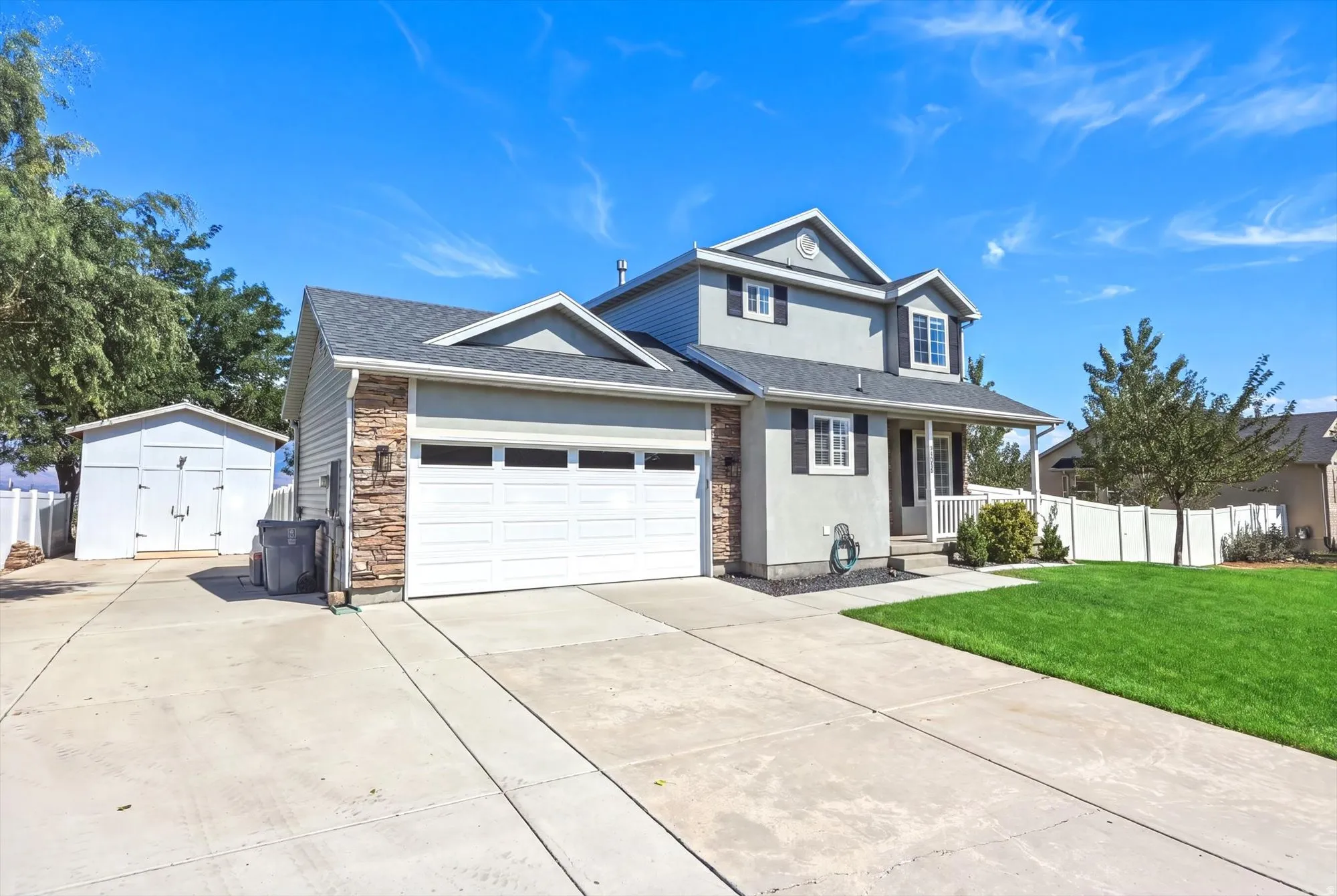 Contemporary residence featuring a two-car garage, stone veneer accents, and a covered porch