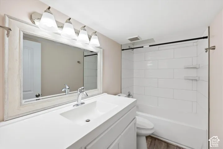Bathroom featuring a single vanity with integrated sink, chrome faucet, and a framed mirror