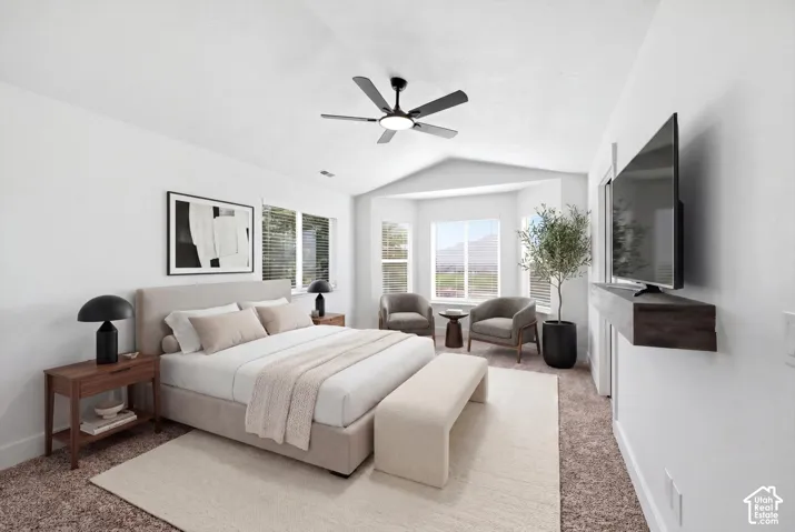 Vaulted ceiling bedroom featuring a modern ceiling fan, bay window with mountain scenery, and built-in floating media shelf
