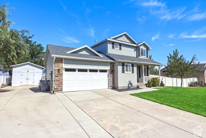 Contemporary residence featuring a two-car garage, stone veneer accents, and a covered porch
