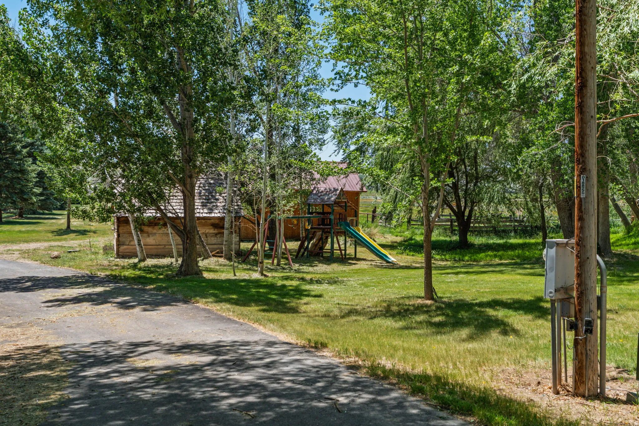 Expansive property featuring mature trees and a paved driveway