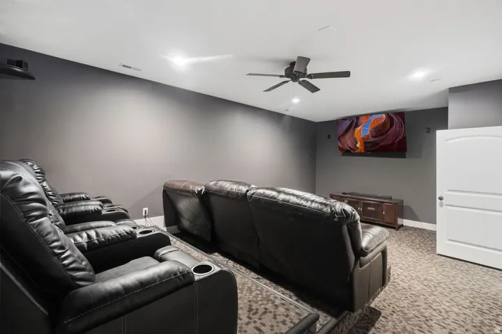 Dedicated media room featuring dark wall paint and patterned carpeting