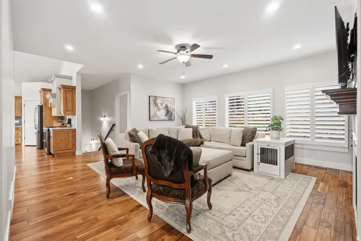 Spacious living area featuring wood-finish flooring, recessed lighting, and a ceiling fan
