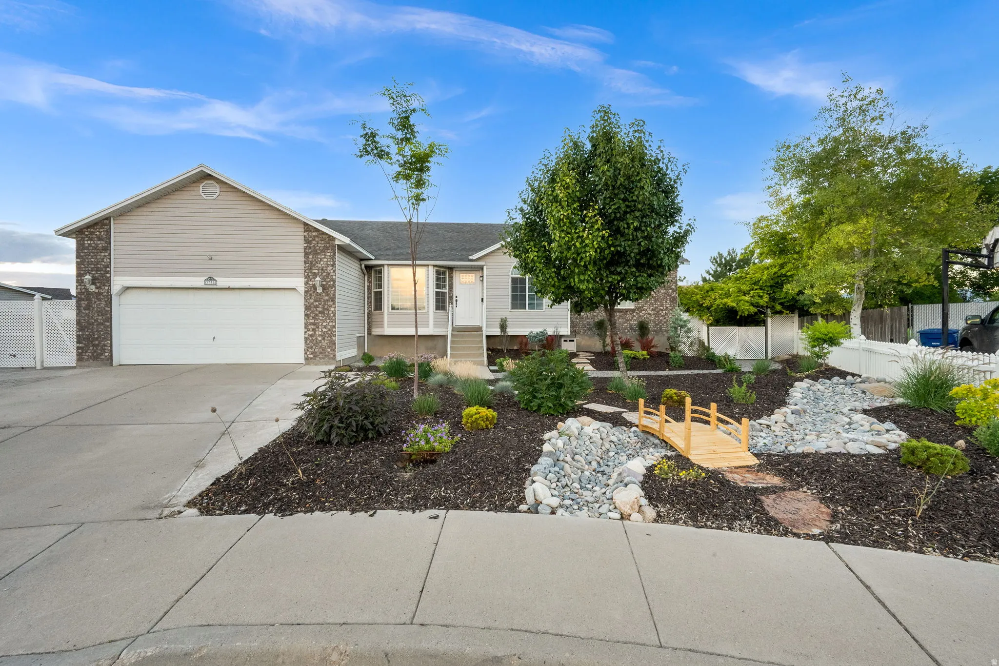 Exterior featuring a two-car garage, stone and siding facade, and a concrete driveway