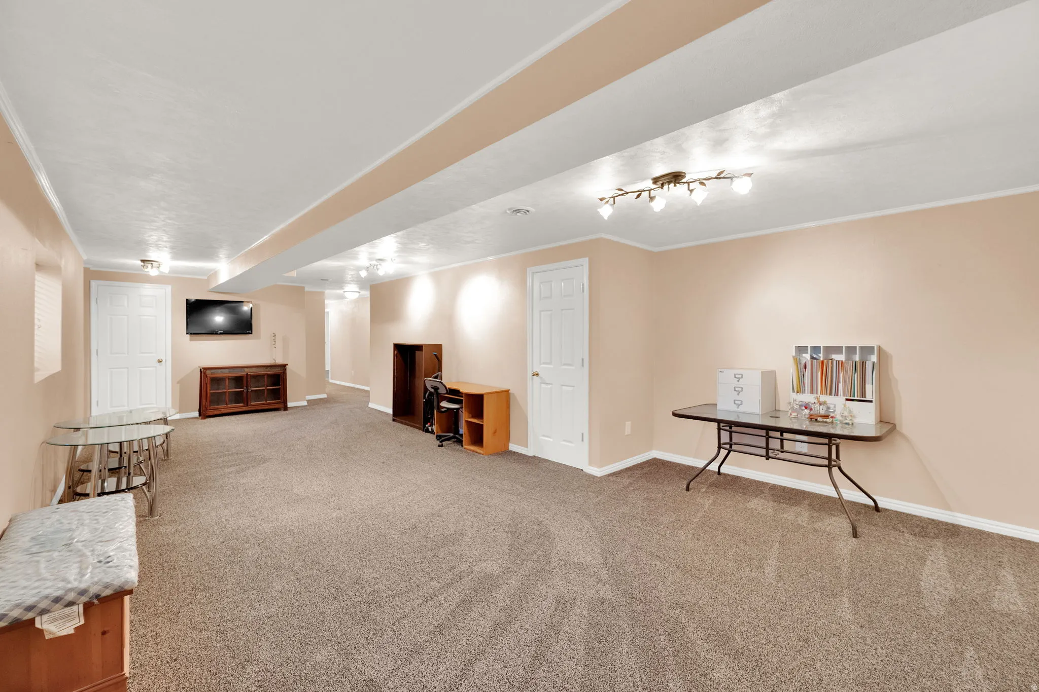 Spacious room featuring neutral carpeting, light-toned walls, recessed lighting, and white trim