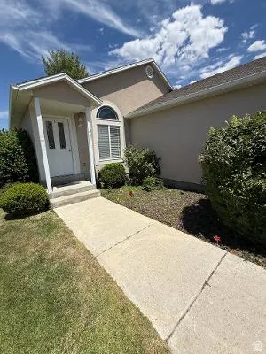 Stucco exterior with an arched window and covered entryway