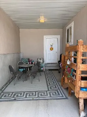 Covered patio space featuring a corrugated metal ceiling and concrete flooring