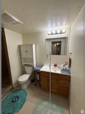 Bathroom featuring a single vanity with wood-finish cabinetry, a white countertop, and a built-in sink