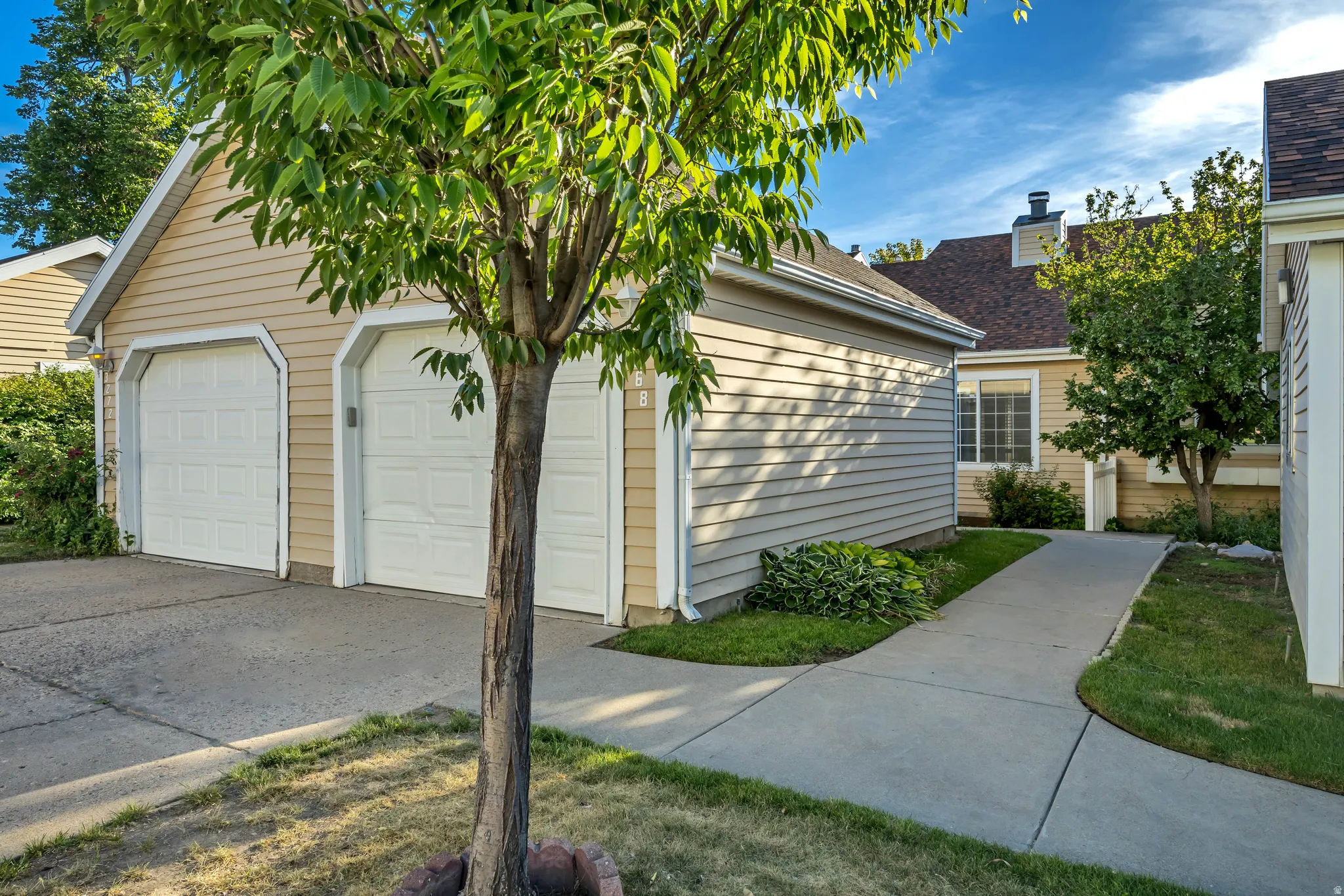 One car garage with panel-style doors and tan siding
