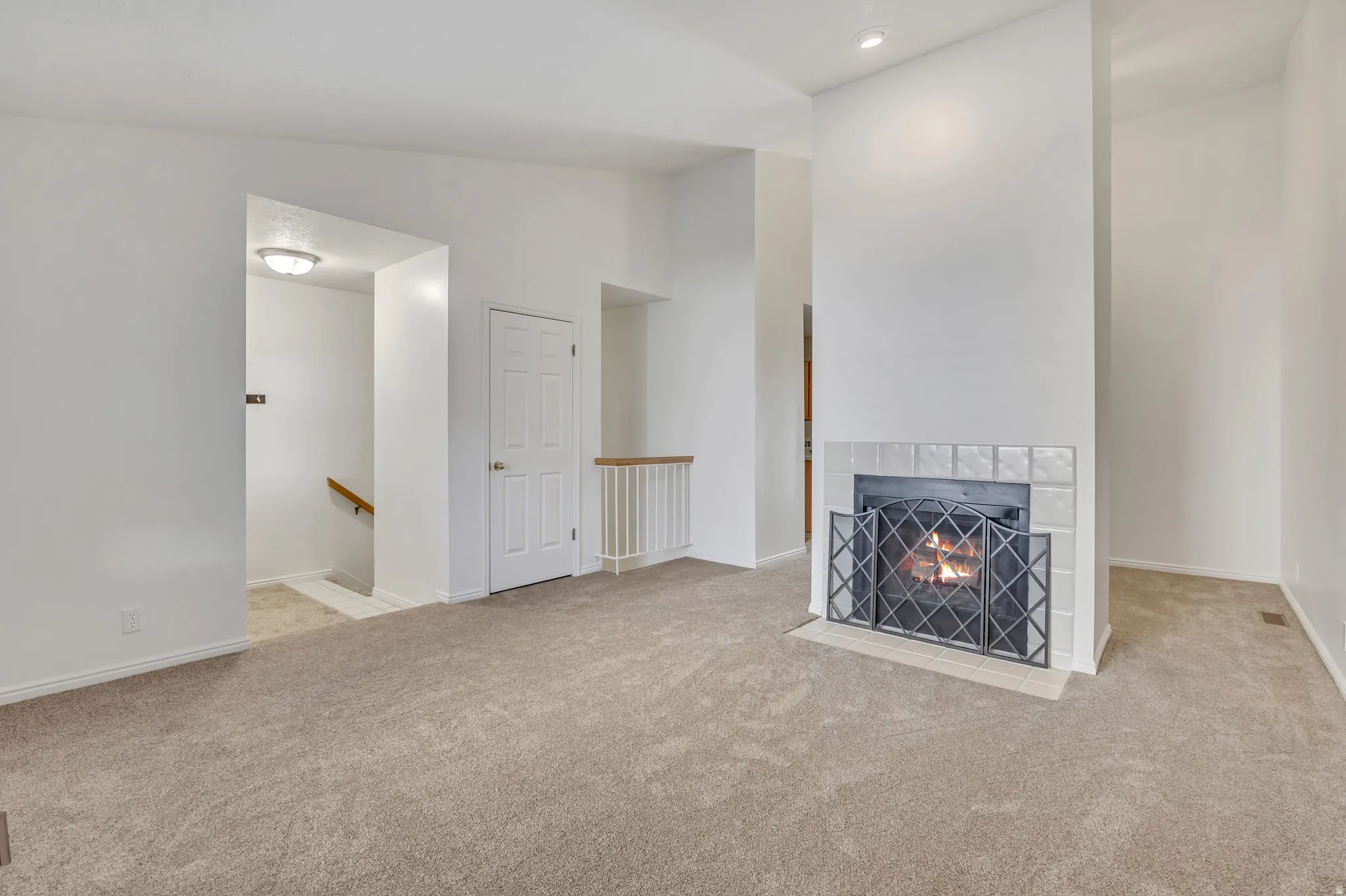 Living area featuring a fireplace with a tiled surround and decorative metal screen