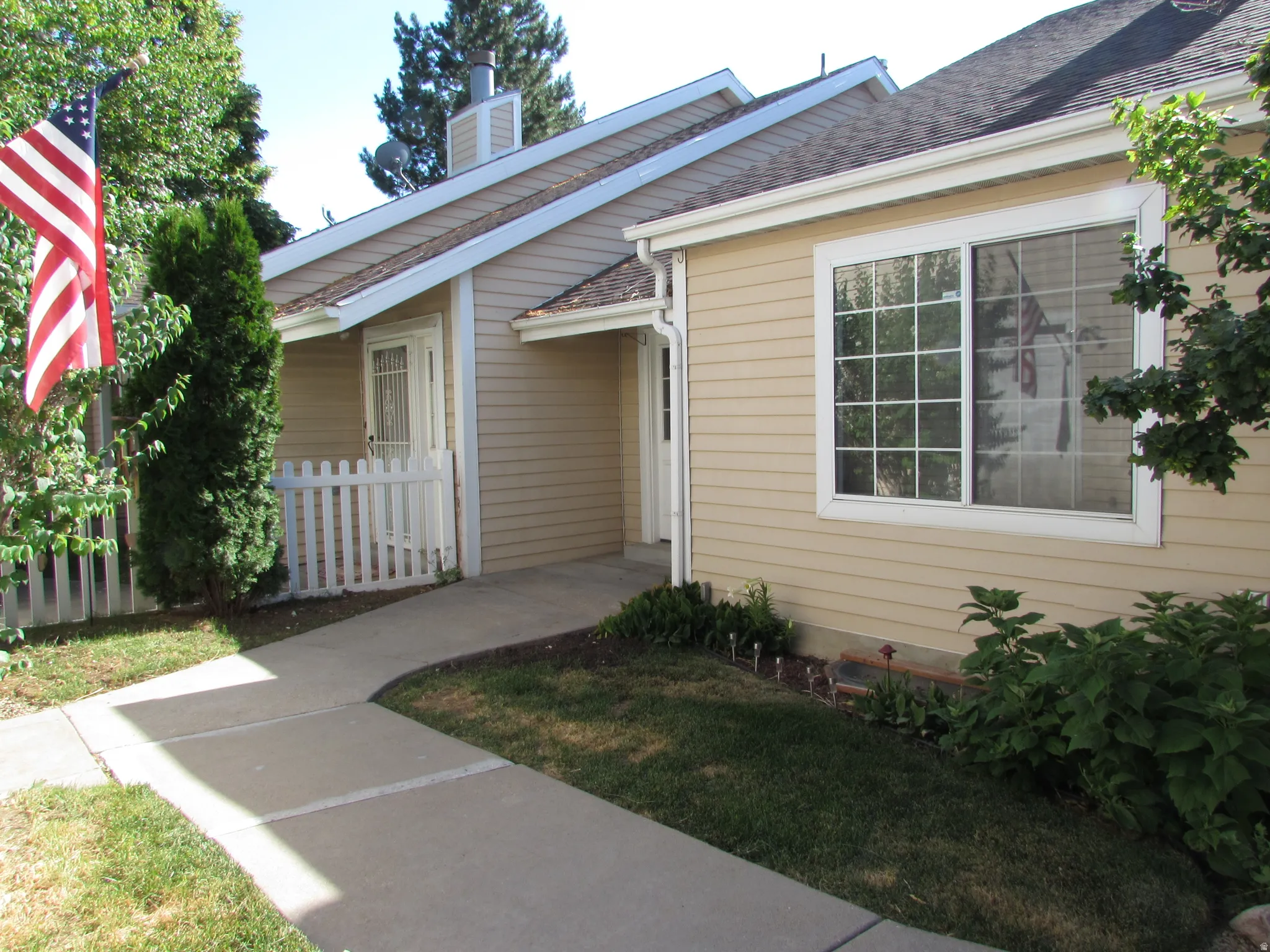 Exterior siding in a neutral tone features a prominent sliding window with grid patterns