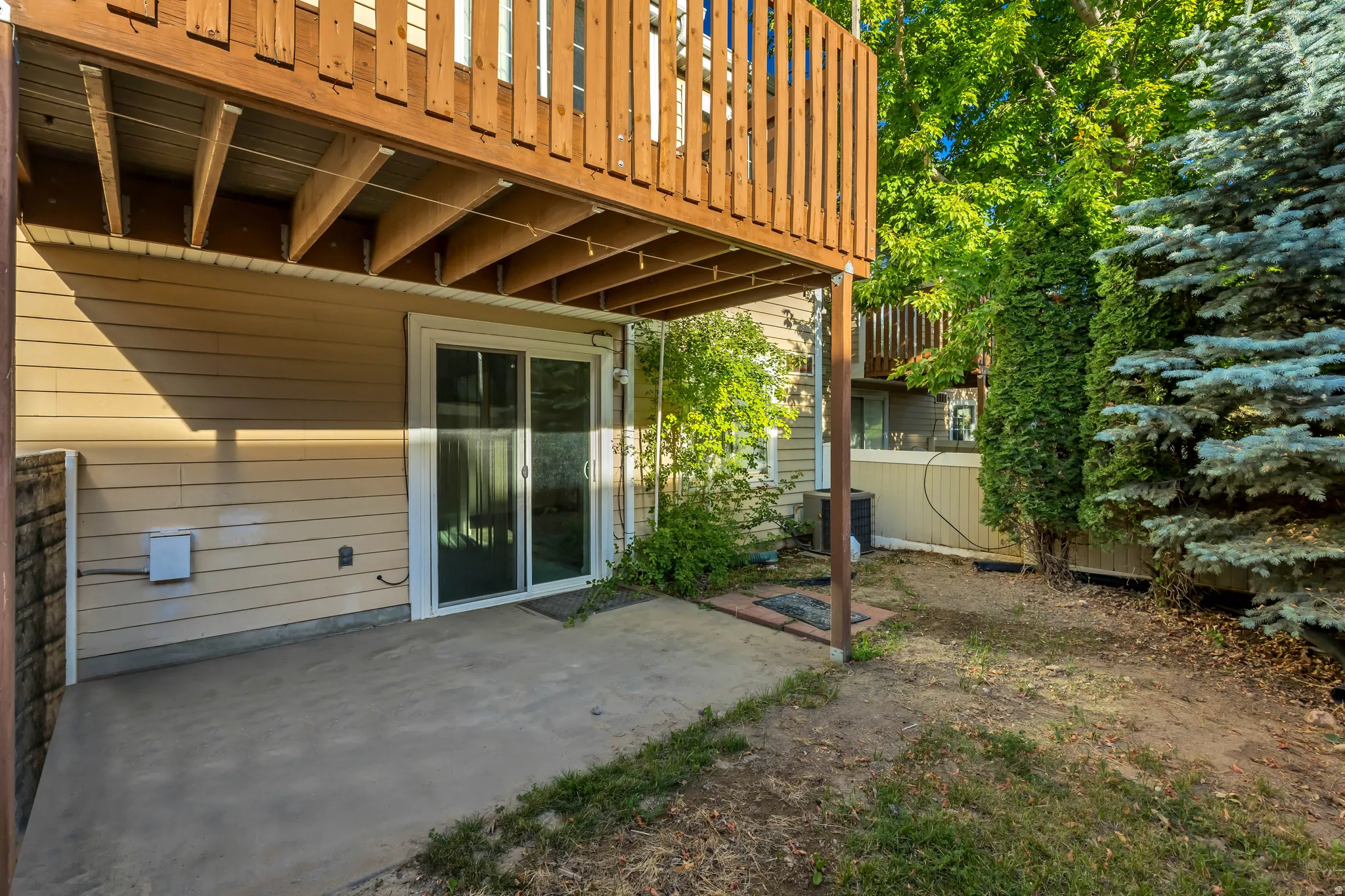 Ground-level concrete patio with a sliding glass door entry