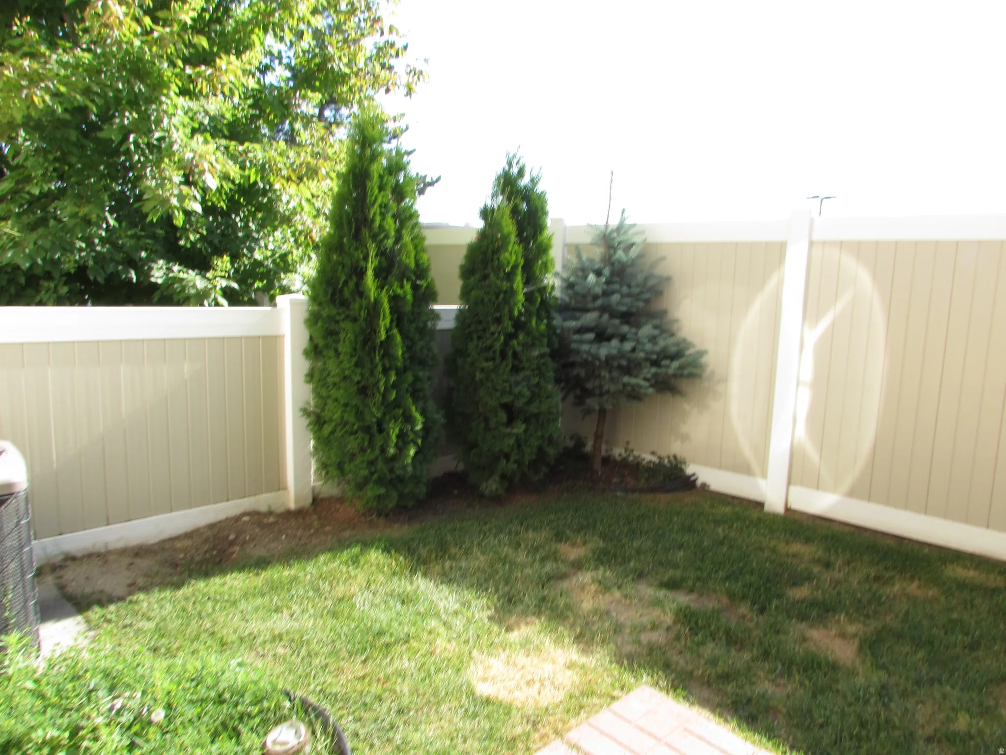 Private backyard space featuring a  privacy fence with vertical panels and a contrasting top rail