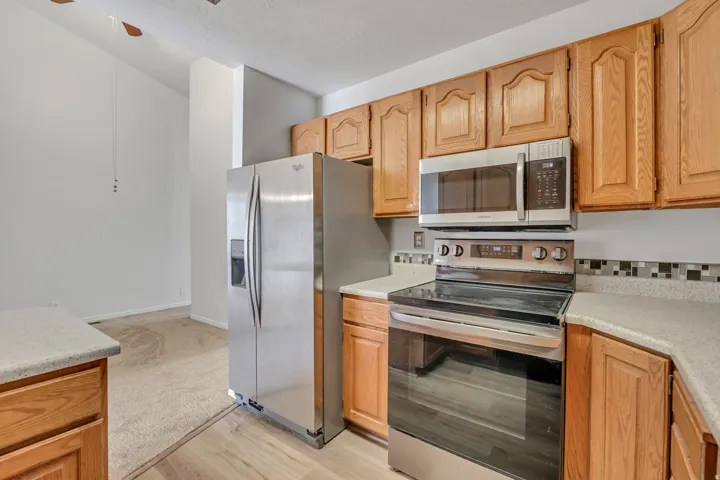 Kitchen featuring wood cabinetry, light-toned countertops, and a mosaic tile backsplash
