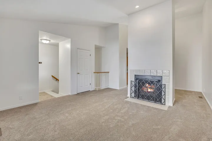 Living area featuring a fireplace with a tiled surround and decorative metal screen