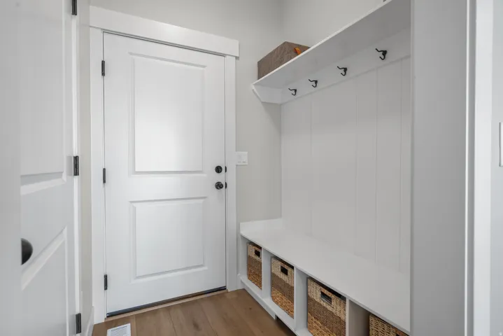 Built-in mudroom bench with cubby storage, upper shelving, and coat hooks