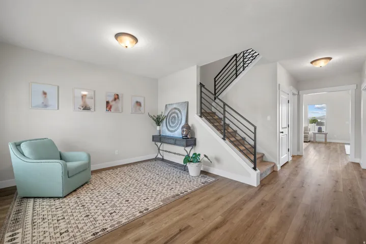 Open foyer featuring contemporary black metal horizontal stair railing, light wood-finish flooring, and neutral wall tones