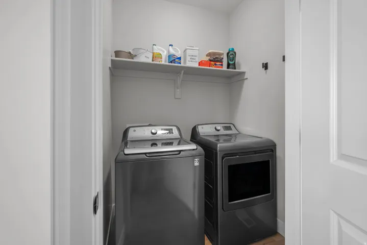 Dedicated laundry area featuring a white wall shelf for storage