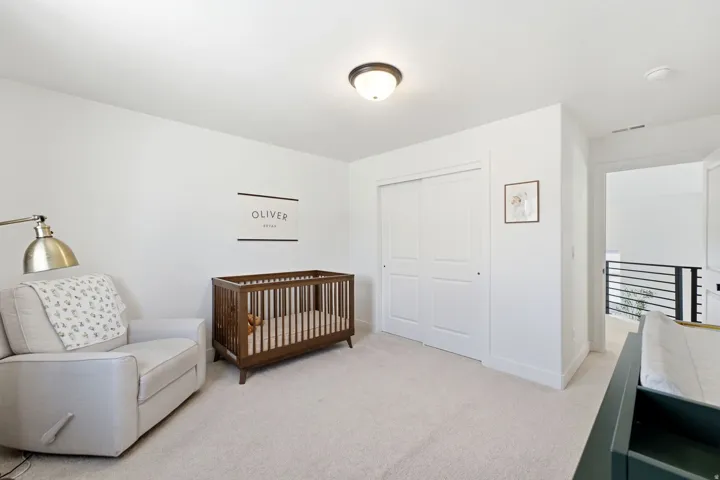 Spacious room featuring light-colored carpeting and white walls
