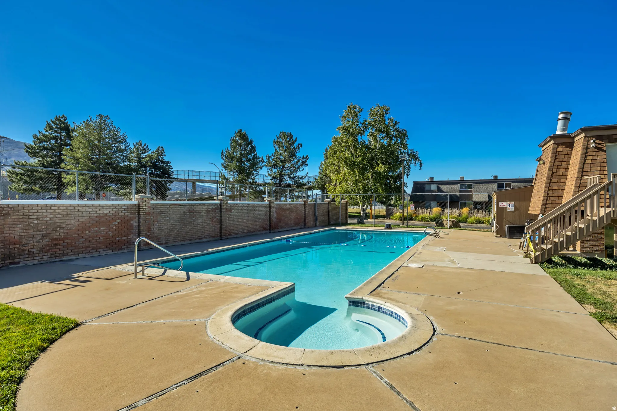 Outdoor swimming pool with integrated spa and concrete surround